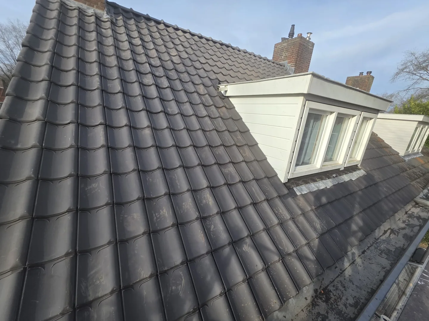 Vernieuwd pannendak met blauw gesmoorde VHV-dakpannen in Tilburg
